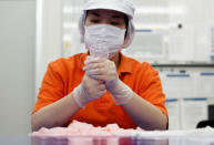 Sagami Rubber Industries' employee checks a condom to test for holes during an inspection process at its factory in Atsugi, Kanagawa Prefecture Japan May 16, 2018. Picture taken May 16, 2018. REUTERS/Kim Kyung-Hoon