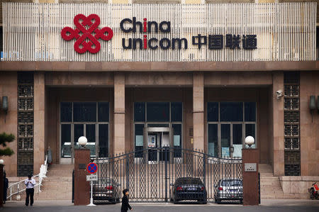 FILE PHOTO: People walk past outside the China Unicom office building in Beijing, October 9, 2013. REUTERS/Petar Kujundzic/File Photo