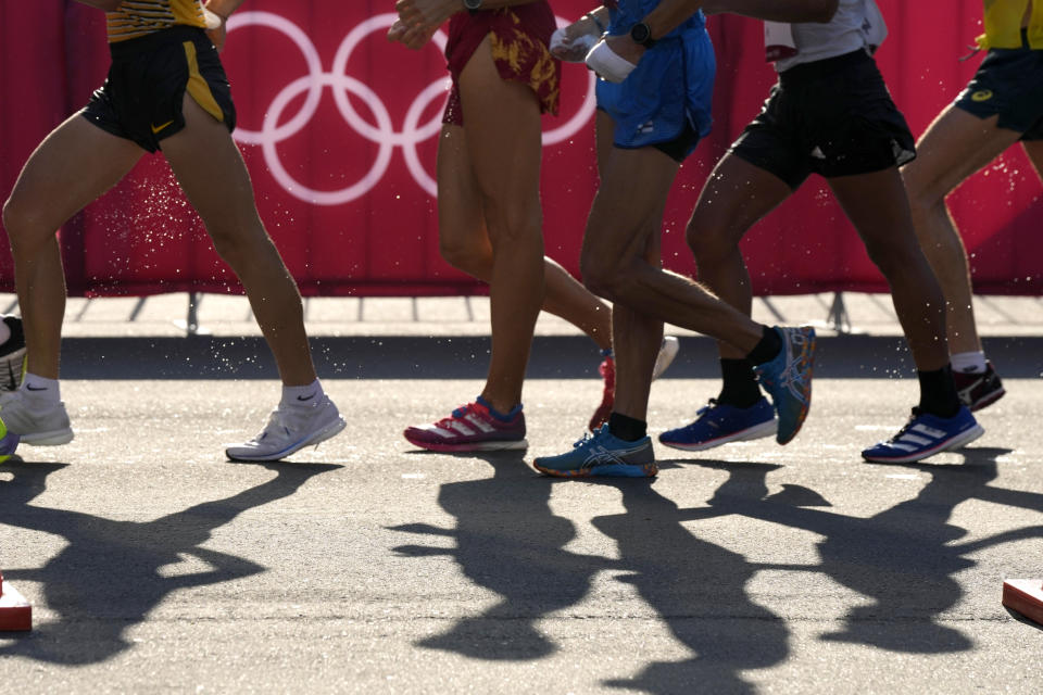 Competitors cast shadow on the race course in the men's 50km race walk at the 2020 Summer Olympics, Friday, Aug. 6, 2021, in Sapporo, Japan. (AP Photo/Shuji Kajiyama)