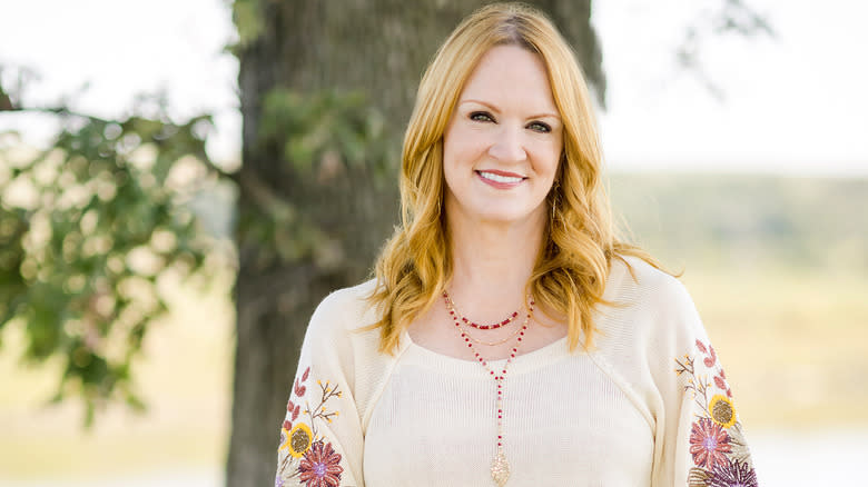 Ree Drummond smiling in white shirt in front of tree