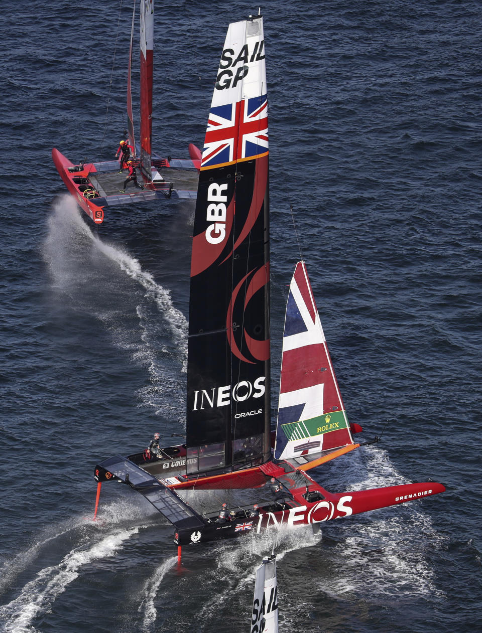 Spain's boat, top, helmed by Phil Robertson and Britain's boat, helmed by Ben Ainslie cross during a race of the Sydney SailGP, on Sydney Harbour, Friday, Feb. 28, 2020. (David Gray/SailGP via AP)