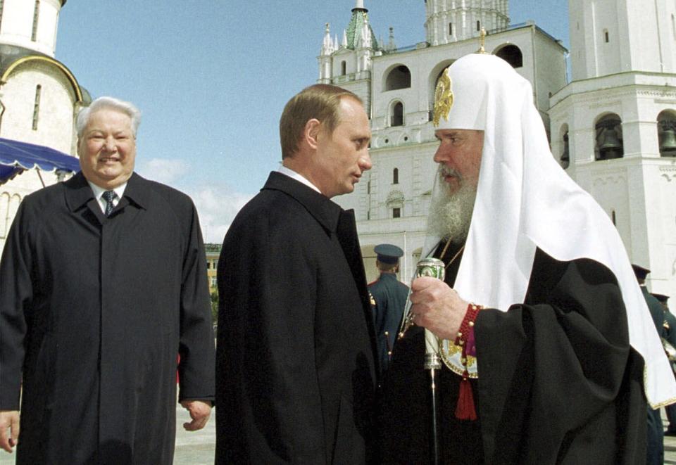 FILE - Russian Orthodox Patriarch Alexi II, right, greets Russian President Vladimir Putin as former President Boris Yeltsin looks on, in Moscow's Kremlin, May 7, 2000. (Sputnik, Kremlin Pool Photo via AP, File)