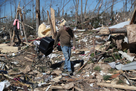 Jed Roberts carries belongings from his sister's destroyed trailer home after two deadly back-to-back tornadoes, in Beauregard, Alabama, U.S., March 5, 2019. REUTERS/Shannon Stapleton