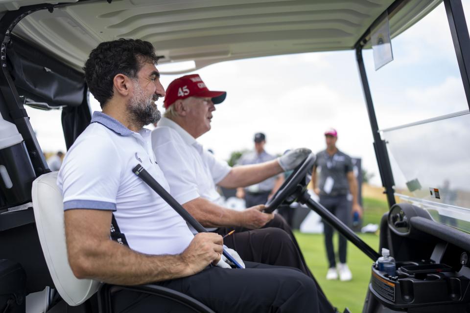 Image:Former president Donald Trump drives a golf cart with Yasir Al-Rumayyan, head of the sovereign wealth fund of Saudi Arabia at the Trump National Golf Club in Bedminster, N.J. on July 28, 2022. (Doug Mills / Redux Pictures)