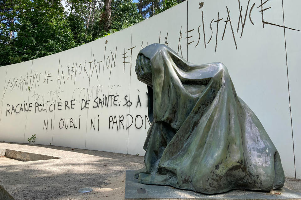 A graffiti reading "Police scum from Saint-Soline to Nanterre - do not forget or forgive" on a monument commemorating Holocaust victims and members of the French resistance memorial, Sunday, July 2, 2023 in Paris suburb Nanterre. In Nanterre, a monument commemorating Holocaust victims and members of the French resistance during World War II was defaced with graffiti Sunday, after it has been vandalized Thursday on the margins of a silent march to pay tribute after the police killing of a teenager. (AP Photo/Cara Anna)