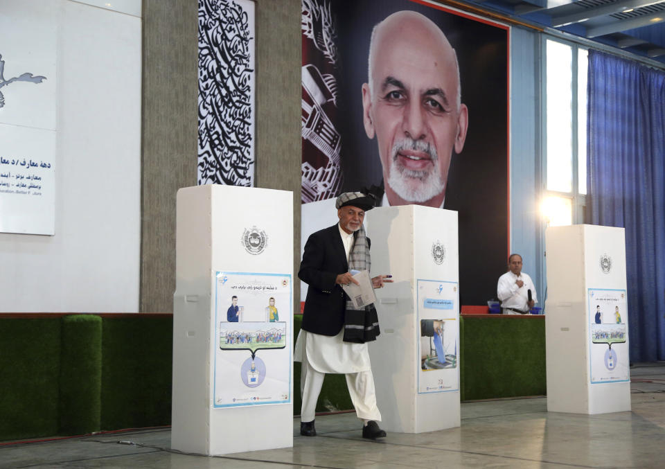 Afghan President Ashraf Ghani, center, walks to the ballot boxes before he casts his vote at Amani high school, near the presidential palace in Kabul, Afghanistan, Saturday, Sept. 28, 2019. Afghans headed to the polls on Saturday to elect a new president amid high security and Taliban threats to disrupt the elections, with the rebels warning citizens to stay home or risk being hurt. (AP Photo/Rahmat Gul)