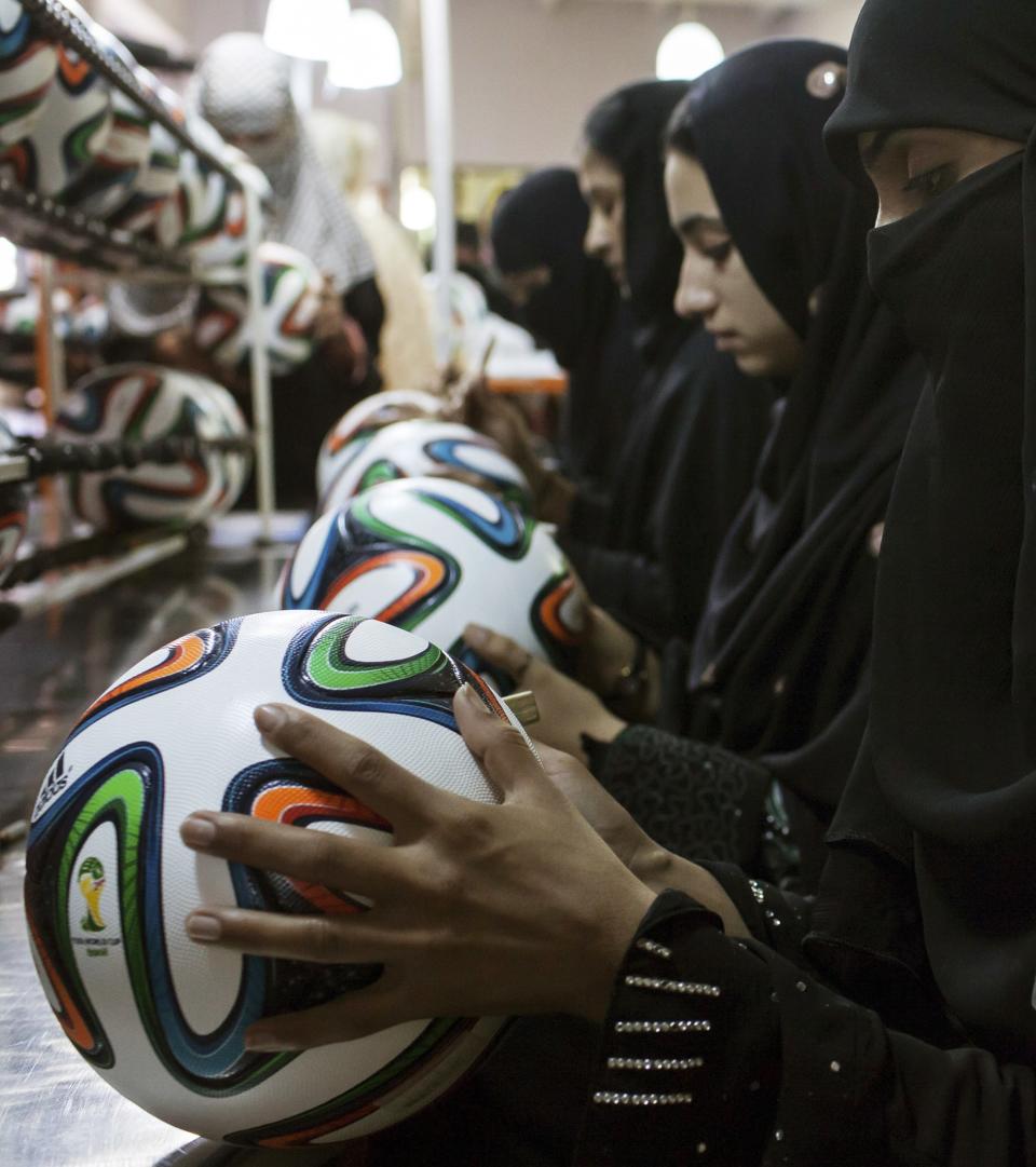 Employees conduct a final check on balls inside the soccer ball factory that produces official match balls for the 2014 World Cup in Brazil, in Sialkot, Punjab province