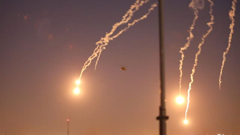 U.S. Army Apache helicopters launch flares as they conduct overflights of the U.S. Embassy in Baghdad