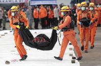 Rescuers carry body bags containing human remains retrieved from from the Java Sea where Sriwijaya Air flight SJ-182 crashed on Saturday, at Tanjung Priok Port in Jakarta, Indonesia, Thursday, Jan. 14, 2021. An aerial search for victims and wreckage of a crashed Indonesian plane expanded Thursday as divers continued combing the debris-littered seabed looking for the cockpit voice recorder from the lost Sriwijaya Air jet. (AP Photo/Dita Alangkara)