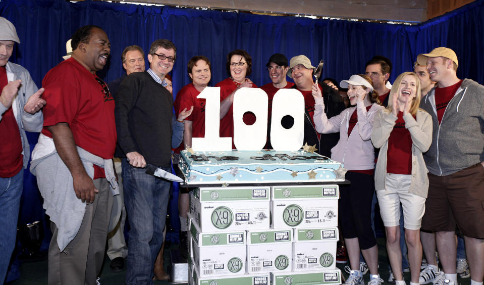 FILE - In this April 14, 2009, file photo cast members celebrate after executive producer and show creator Greg Daniels, holding knife, cuts a cake celebrating the 100th episode of the television show "The Office" in Malibu, Calif. Netflix's announced that NBC's hit show "The Office" will be pulled from its lineup after 2020 and head to NBCUniversal's upcoming service. In a tweet Tuesday, June 25, Netflix said it was "sad" that NBC was taking back the show but added it will still be on Netflix for the next year and a half. (AP Photo/Matt Sayles, File)