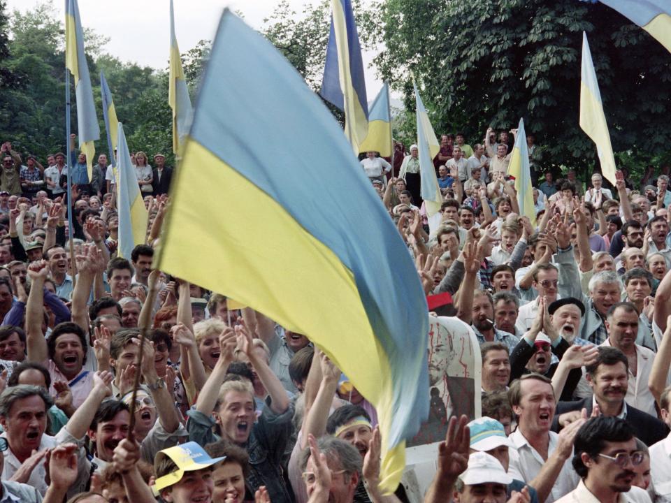 Ukrainians brandish flags and celebrate the independence of ukraine in front of the Communist Party's central committee headquarters on August, 25, 1991, in Kyiv.