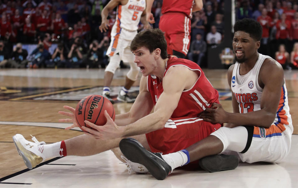 Wisconsin forward Ethan Happ (22) looks to get a pass off against Florida forward Kevarrius Hayes (13) in overtime of an East Regional semifinal game of the NCAA men's college basketball tournament, Saturday, March 25, 2017, in New York. (AP Photo/Frank Franklin II)