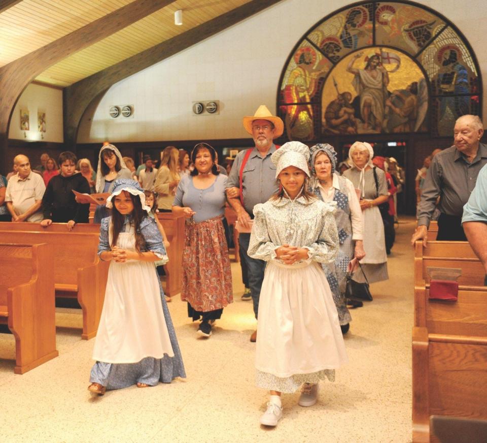 Churchgoers dressed as Acadians walk down the aisle of St. Hilary's as part of the annual French Mass, dedicated to Acadian Culture, Aug. 15, 2019.