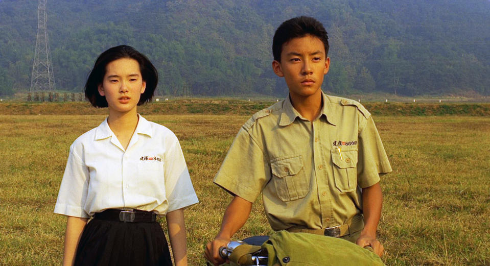 Chang stands next to Lisa Yang in a field in a still from "A Brighter Summer Day"