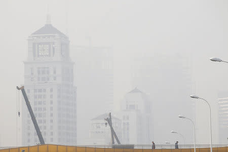 People walk on a bridge amid heavy smog in Shanghai, China December 23, 2016. REUTERS/Aly Song