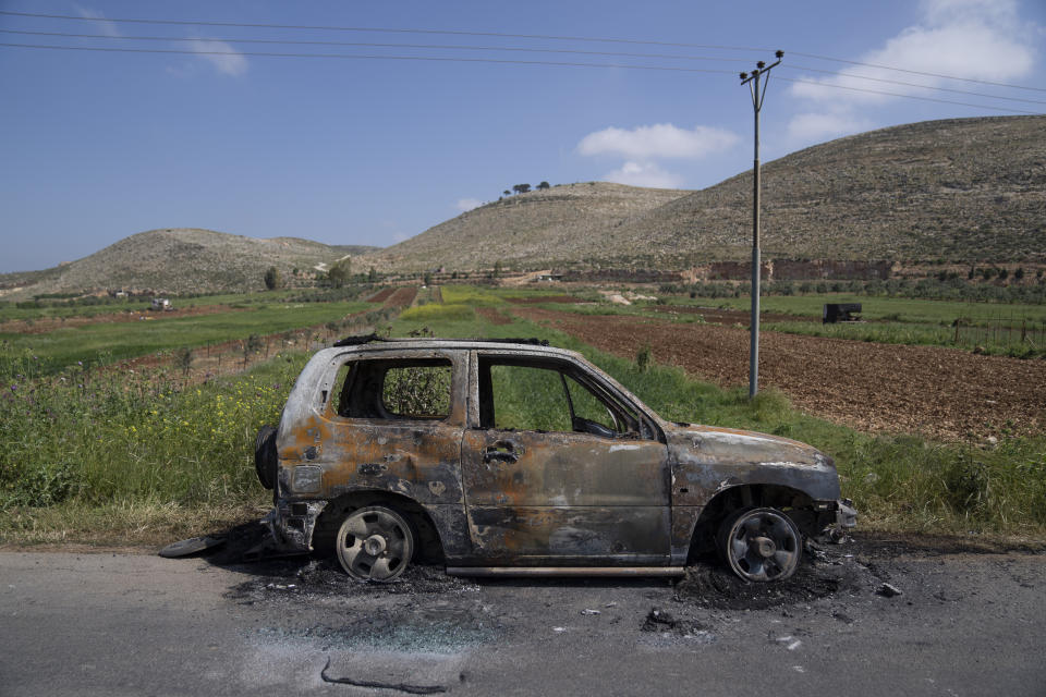 A torched vehicle is seen in the West Bank village of al-Mughayyir, Saturday, April 13, 2024. Dozens of Israeli settlers stormed into a Palestinian village in the Israeli-occupied West Bank on Friday, shooting and setting houses and cars on fire. The rampage killed a Palestinian man and wounded 25 others, Palestinian health officials said. An Israeli rights group said the settlers were searching for a missing 14-year-old boy from their settlement. (AP Photo/Nasser Nasser)