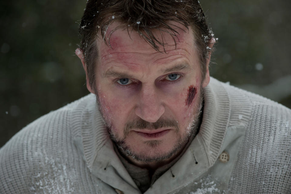 Liam Neeson looking beat up and intense, standing out in the snow