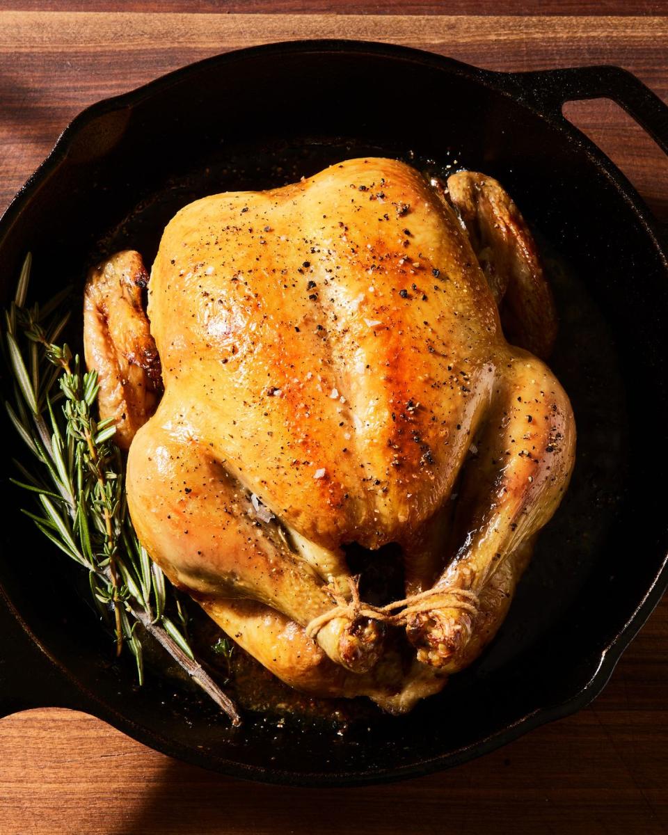 roast chicken tied in a skillet with rosemary