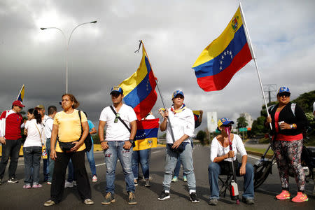 Opposition supporters wave Venezuelan national flags as they block a highway during a protest against Venezuelan President Nicolas Maduro's government in Caracas, Venezuela May 15, 2017. REUTERS/Carlos Garcia Rawlins