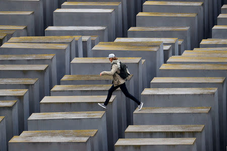A visitor jumps on the concrete elements of the Holocaust memorial as Germany marks the 80th anniversary of Kristallnacht, also known as Night of Broken Glass, in Berlin, Germany November 9, 2018. REUTERS/Fabrizio Bensch