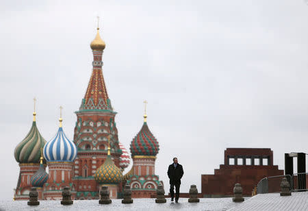 FILE PHOTO: A man walks along Red Square, with the mausoleum of Soviet state founder Vladimir Lenin (R) and St. Basil's Cathedral seen in the background, in central Moscow, Russia December 21, 2015. REUTERS/Maxim Shemetov/File Photo