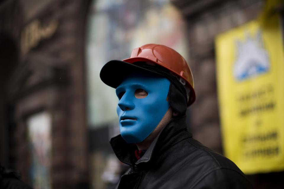 An anti-Yanukovych protester protects the entrance of a shop occupied by demonstrators still camped out on Kiev's Independence Square, the epicenter of the country's current unrest, Ukraine, Tuesday, Feb. 25, 2014. The Ukrainian parliament on Tuesday delayed the formation of a new government, reflecting political tensions and economic challenges following the ouster of the Russia-backed president. Parliament speaker Oleksandr Turchinov, who was named Ukraine's interim leader after President Viktor Yanukovych fled the capital, said that a new government should be in place by Thursday, instead of Tuesday, as he had earlier indicated. (AP Photo/Emilio Morenatti)