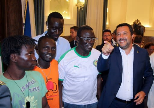 Italy's Interior Minister Matteo Salvini, right, speaks with farm labourers in Foggia, southern Italy, on Tuesday