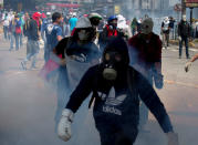 Manifestantes antigubernamentales avanzan con máscaras antigases durante una protesta para demandar la libertad de estudiantes detenidos en Caracas, Venezuela, el lunes 12 de mayo de 2014.(AP Photo/Fernando Llano)