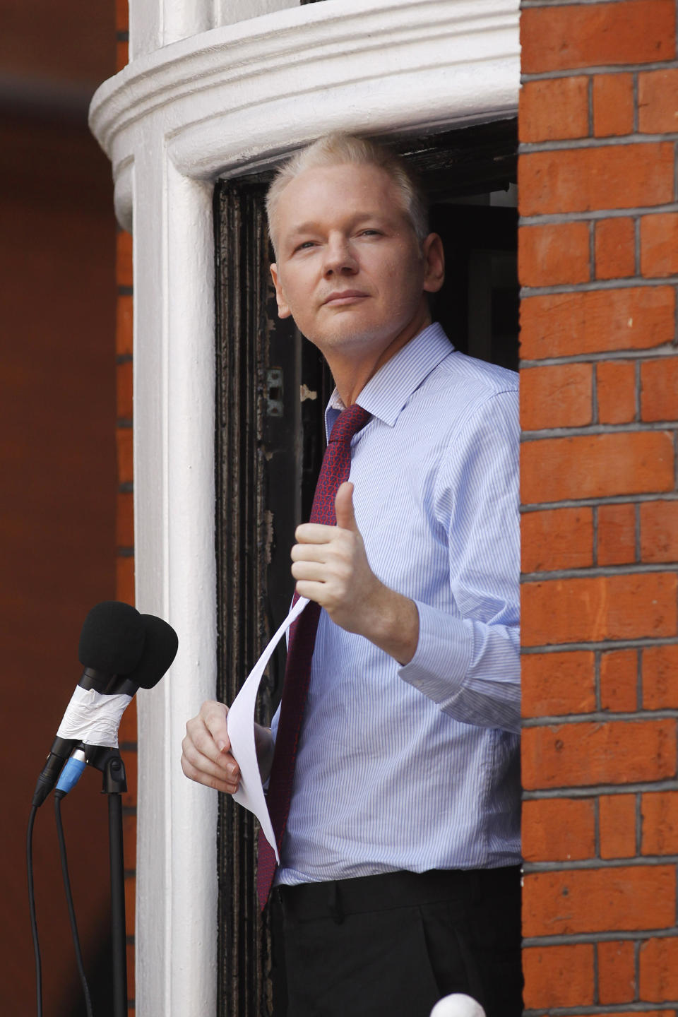 FILE - In this Sunday, Aug. 19, 2012 file photo, WikiLeaks founder Julian Assange gestures as he appears at a window of Ecuadorian Embassy in central London to make a statement to the media and supporters. Police in London arrested WikiLeaks founder Assange at the Ecuadorean embassy Thursday, April 11, 2019 for failing to surrender to the court in 2012, shortly after the South American nation revoked his asylum. (AP Photo/Sang Tan, FIle)