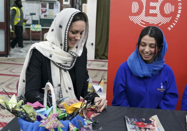 The Princess of Wales makes an origami crane with Dila Kaya, 14, one of two schoolgirls who made hundreds of origami cranes to raise funds for the Turkey-Syria Earthquake Appeal, during a visit to the Hayes Muslim Centre in west London 
