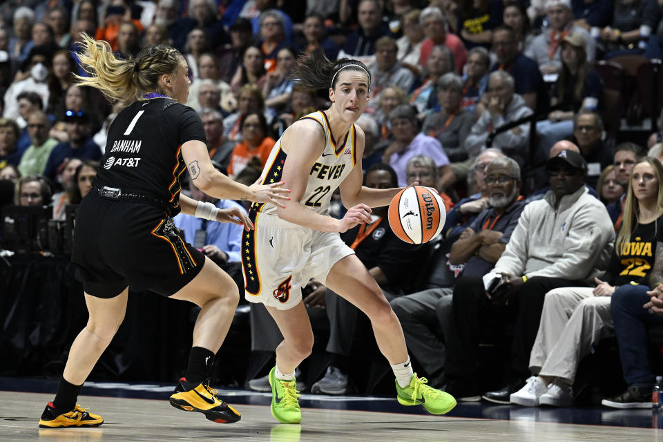 Indiana Fever guard Caitlin Clark (22) drives against Connecticut Sun guard Rachel Banham (1) during the fourth quarter of a WNBA basketball game, Tuesday, May 14, 2024, in Uncasville, Conn. (AP Photo/Jessica Hill)