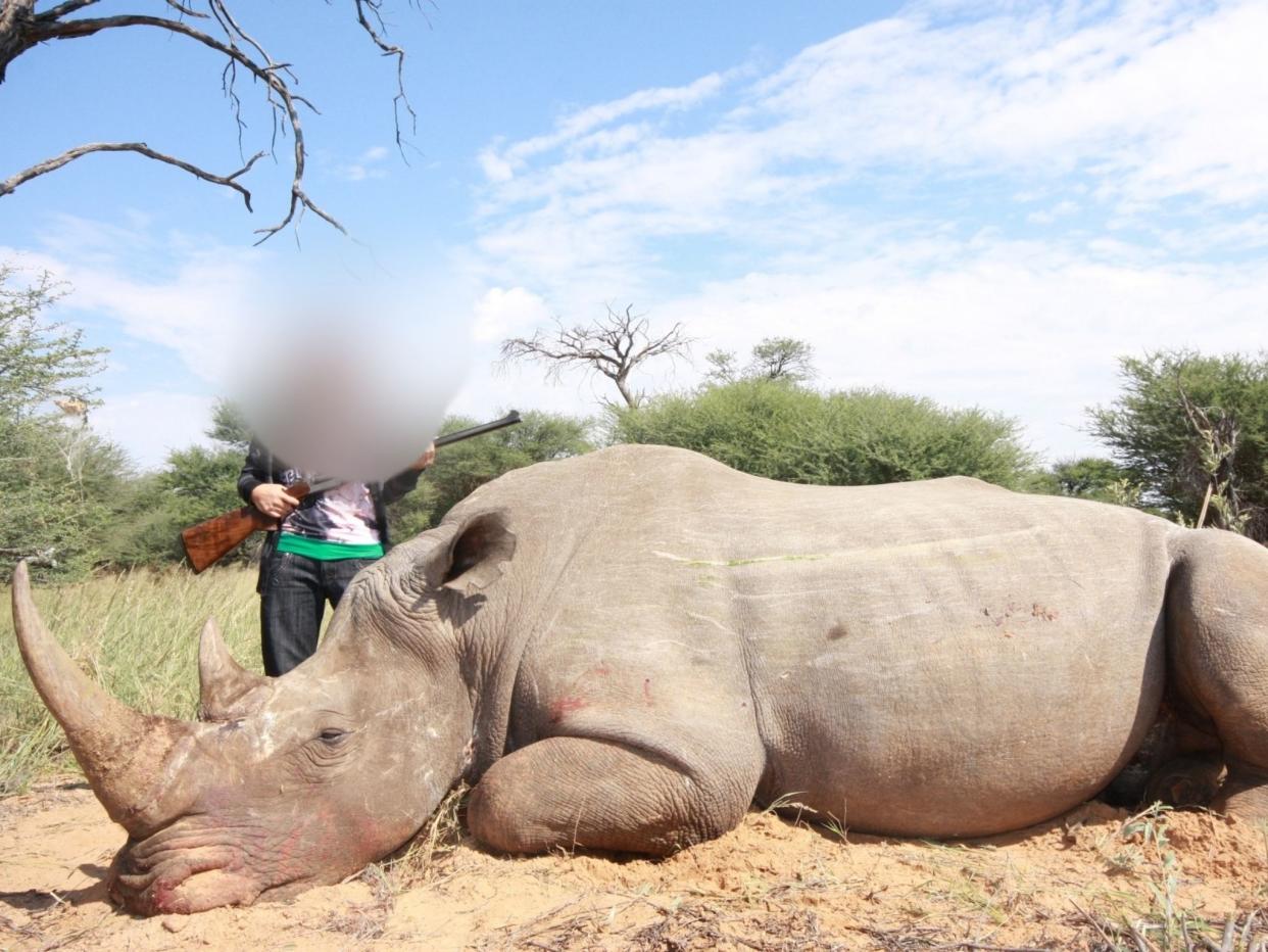 <p>A trafficked sex-worker posing with a rhino in South Africa</p> (Paul O’Sullivan)