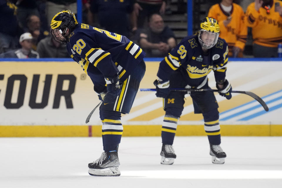 Michigan defenseman Keaton Pehrson (20) and defenseman Jay Keranen (90) react after the team lost to Quinnipiac during an NCAA semifinal game in the Frozen Four college hockey tournament Thursday, April 6, 2023, in Tampa, Fla. (AP Photo/Chris O'Meara)