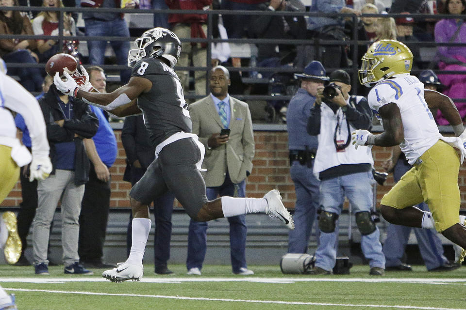 Washington State wide receiver Easop Winston Jr. (8) catches a pass which he runs for a touchdown in front of UCLA defensive back Darnay Holmes (1) during the first half of an NCAA college football game in Pullman, Wash., Saturday, Sept. 21, 2019. (AP Photo/Young Kwak)