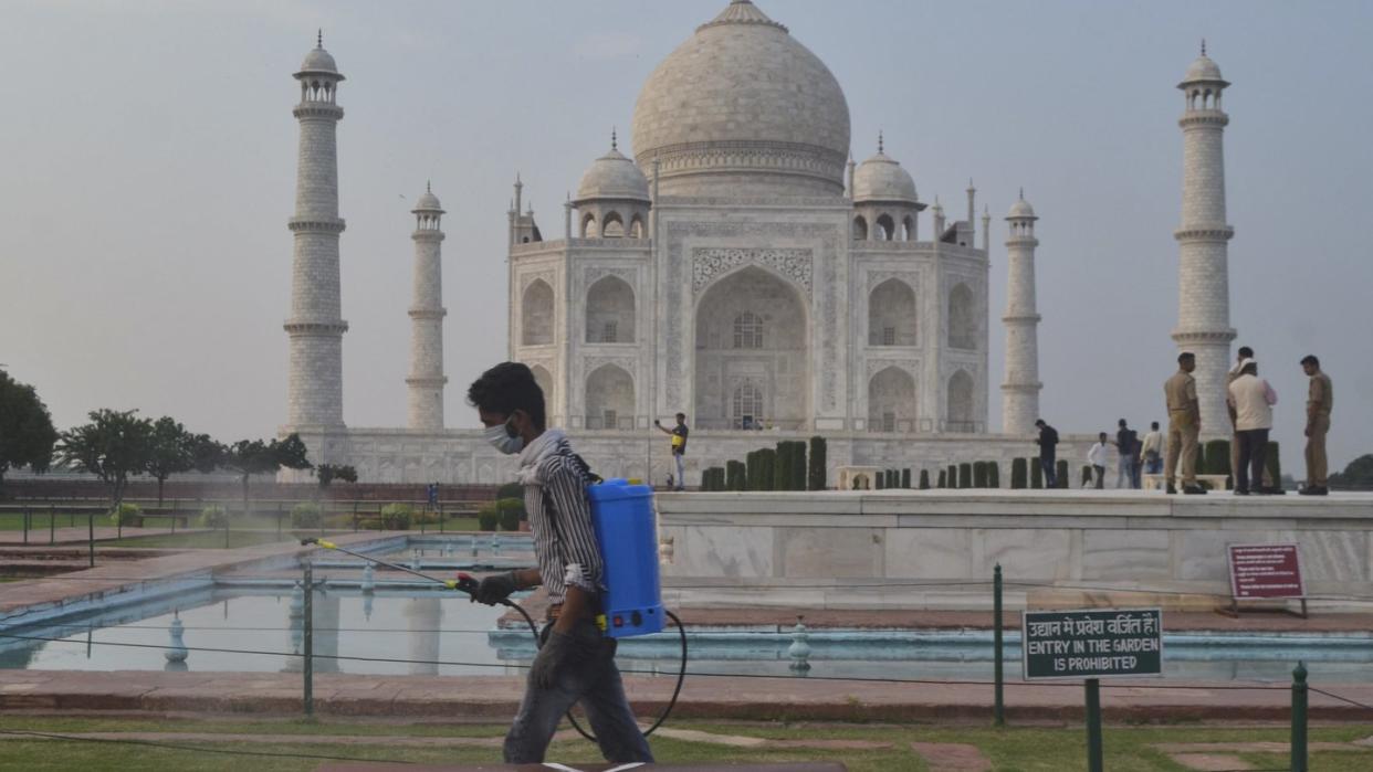 Ein Mann sprüht Desinfektionsmittel in einem Bereich vor dem Taj Mahal im nordindischen Agra. Das berühmte Mausoleum ist für Besucher wiedereröffnet worden, nachdem es Corona-bedingt mehr als sechs Monate lang geschlossen war.