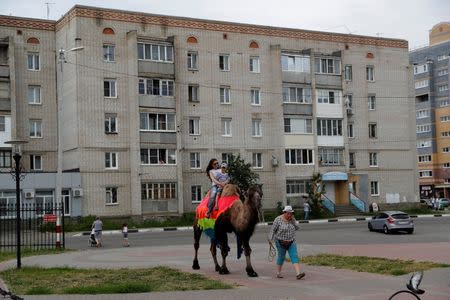 A woman and child take a camel ride in Bor, Nizhny Novgorod, Russia July 1, 2018. REUTERS/Darren Staples