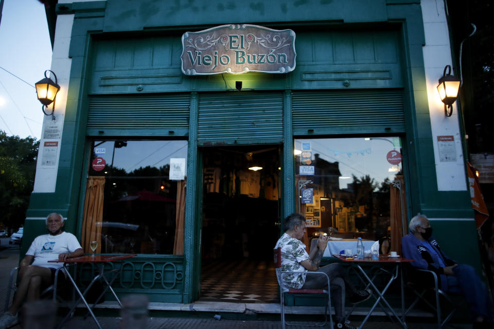 People sit at El Viejo Buzón, a traditional cafe in Buenos Aires, Argentina, Sunday, Nov. 22, 2020. With the end of the lockdown to avoid the spread of the new coronavirus, the traditional cafes of Buenos Aires have begun to revive after seven months that plunged them into a crisis, representative of the paralysis that has caused the closure of thousands of small businesses in Argentina. (AP Photo/Natacha Pisarenko)