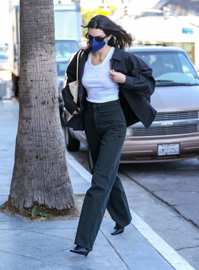 Kendall Jenner wears a white top, black leggings and Nike sneakers while  stepping out for lunch