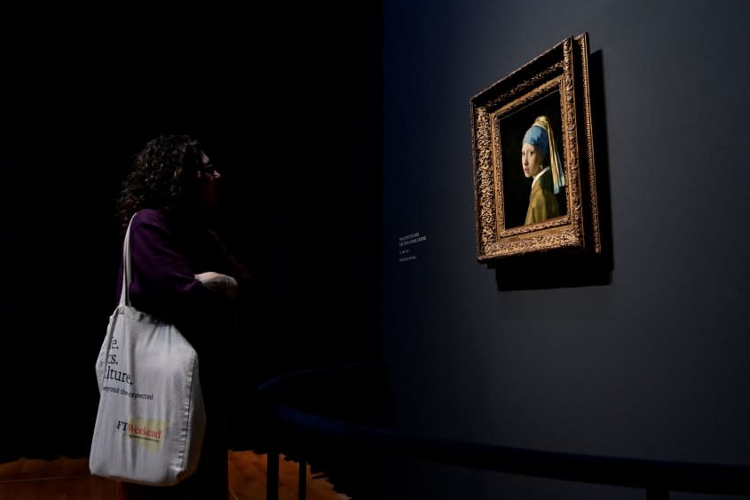 A woman looks at the Vermeer painting 