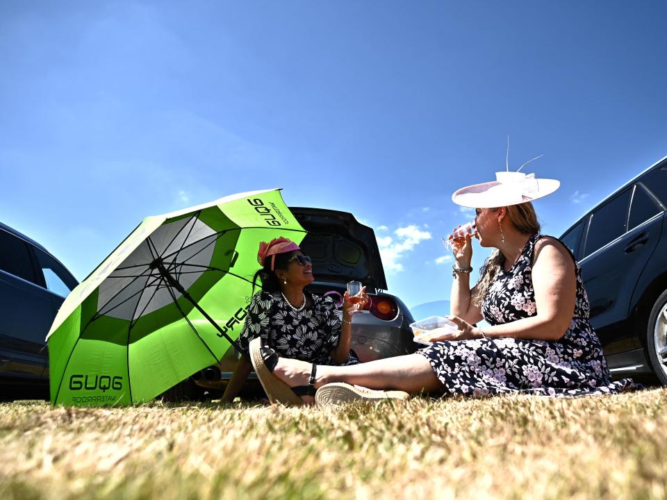 Attendees share a drink in car park.