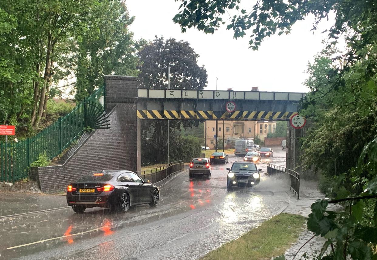 Cars driving through floodwater on Gringer Hill in Maidenhead (PA)