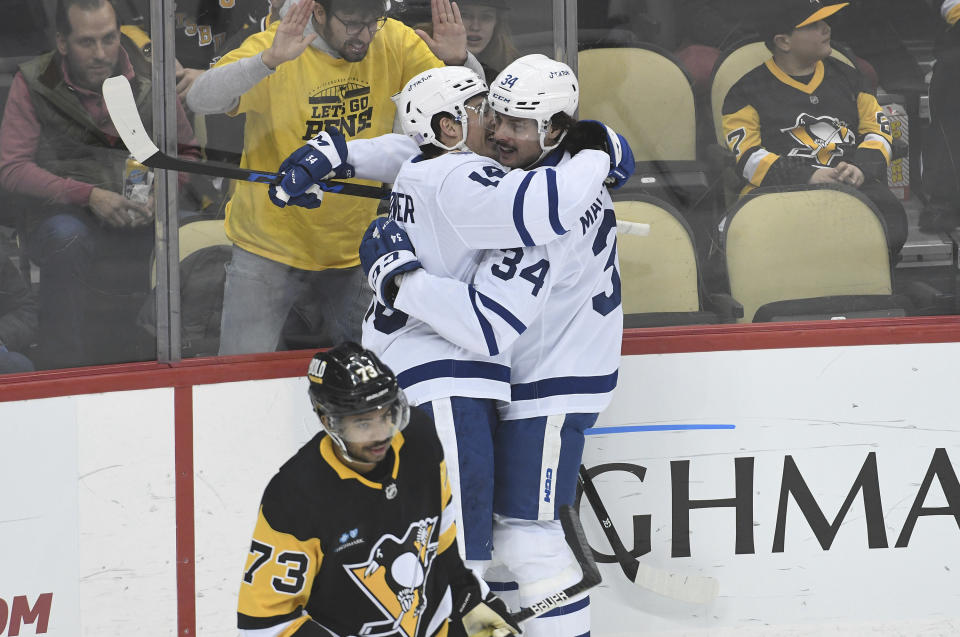 Toronto Maple Leafs right wing Mitchell Marner celebrates with center Auston Matthews (34) near Pittsburgh Penguins defenseman Pierre-Olivier Joseph (73) after scoring during the first period of an NHL hockey game, Saturday, Nov. 26, 2022, in Pittsburgh. (AP Photo/Philip G. Pavely)