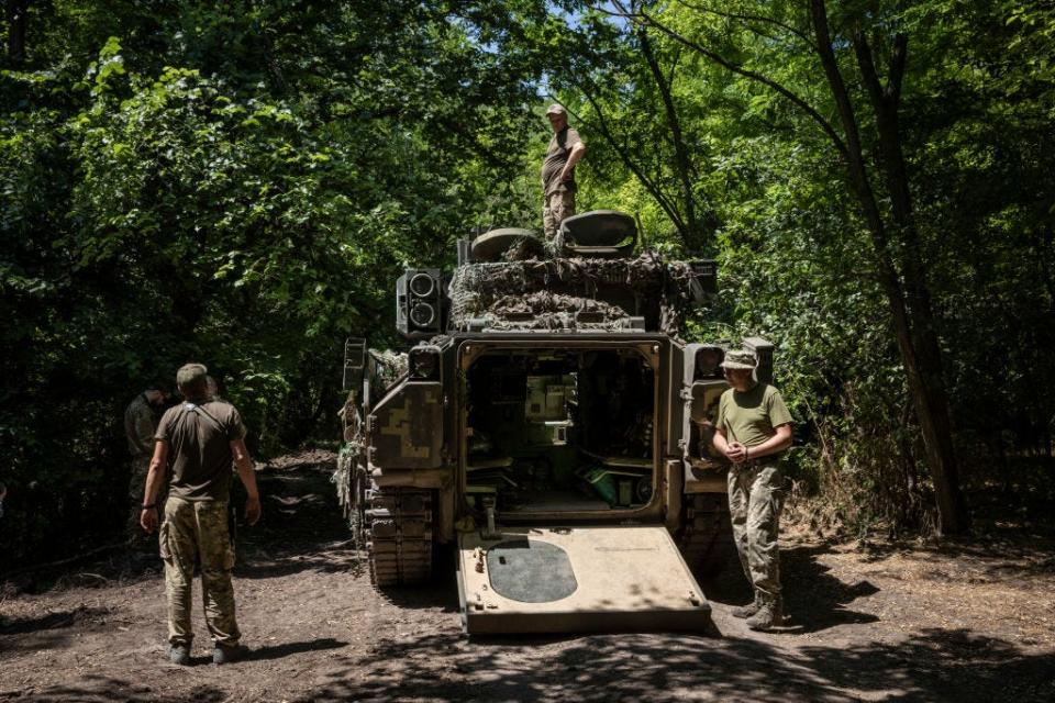 Soldiers and mechanics from Ukraine's 47th Mechanized Brigade test drive a US made Bradley Fighting Vehicle at a secret workshop in a wooded area in Zaporizhzhia Region, Ukraine