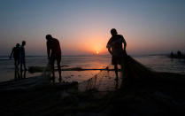 <p>Pakistani fisherman sort out their nets at sunset on the coast of the Arabian Sea, in Karachi, Pakistan, Tuesday, Sept. 27 2016. (AP Photo/Shakil Adil)</p>