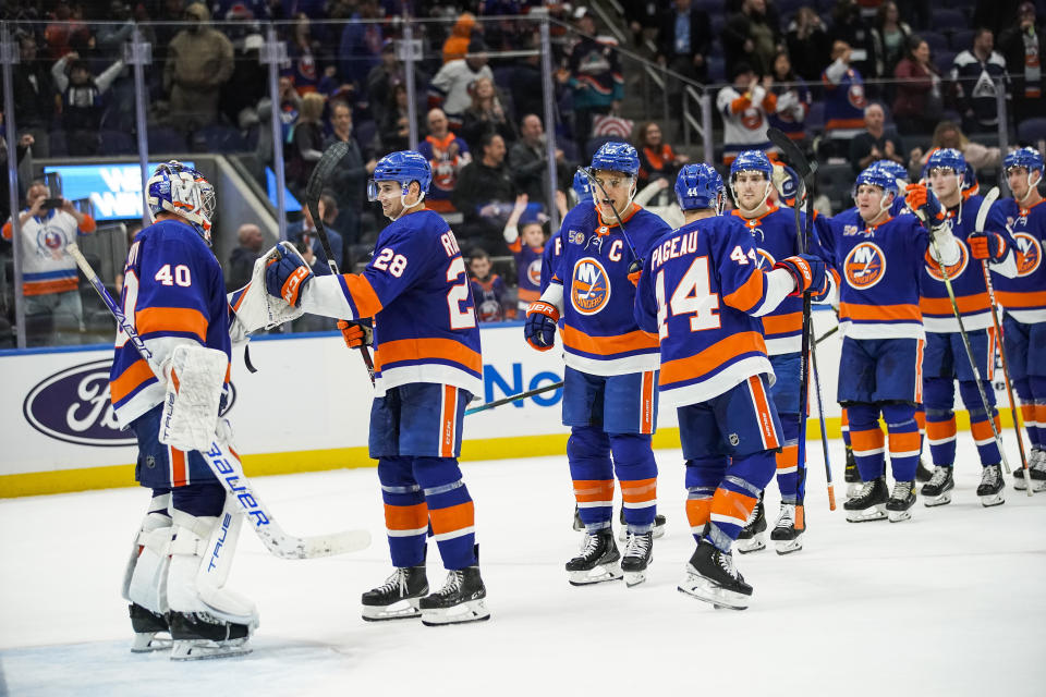 New York Islanders players celebrate after defeating the Colorado Avalanche in an NHL hockey game, Saturday, Oct. 29, 2022, in Elmont, N.Y. (AP Photo/Eduardo Munoz Alvarez)