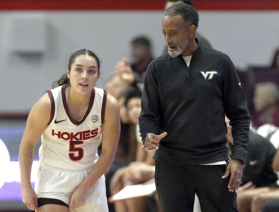 Virginia Tech's Georgia Amoore (5) and head coach Kenny Brooks, right, look on in the first half of an NCAA college basketball game against UNC-Greensboro in Blacksburg, Va., Monday, Nov. 20 2023. (Matt Gentry/The Roanoke Times via AP)