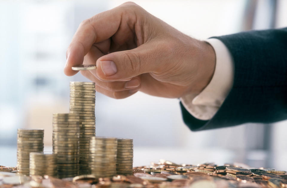 Hand of a mid adult man, wearing a siut, is stacking Euro coins. (2XL-File)