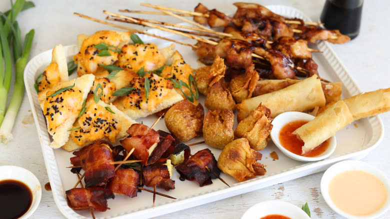 pu pu platter on serving tray with sauces