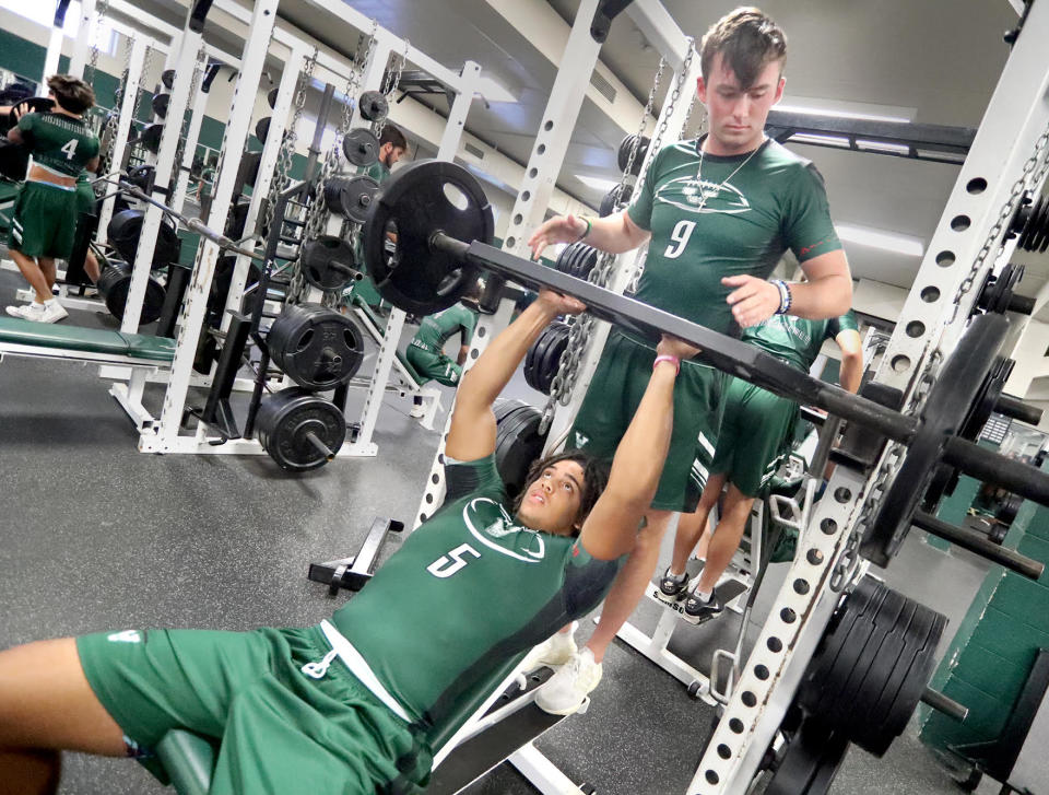 Venice High quarterback Jadyn Glasser lifts as fellow quarterback Ryan Downes spots during a team weightlifting session on Tuesday.
