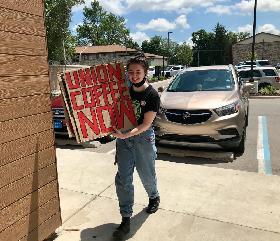 Barista and Michigan State University student Grace Norris brings signs into the Lansing Township Starbucks before a union vote on June 9, 2022.